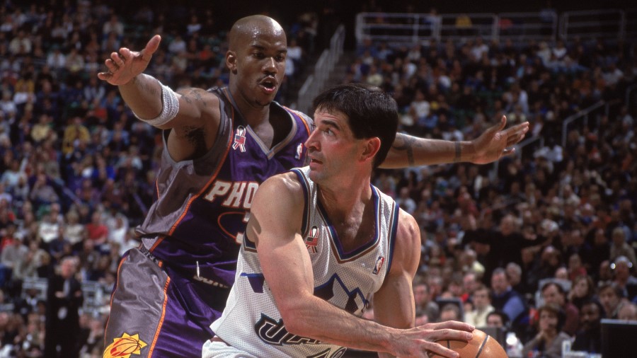 John Stockton #12 of the Utah Jazz looks to move the ball as he is guarded by Stephon Marbury #3 of...